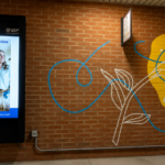 Wall-mounted digital message board installed on a brick wall at a commercial property in the DC, Maryland, and Northern Virginia region.