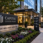 Property managers reviewing office building signage plans outside a modern commercial office building with monument, wayfinding, lobby, and ADA signage in the Washington DC metropolitan area.