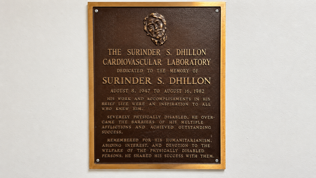 Bronze architectural plaque with raised lettering and dimensional detailing mounted on an interior commercial building wall.