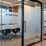 Modern office glass partitions featuring full-coverage frosted privacy film, horizontal privacy bands, and decorative frosted glass designs.